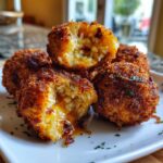 Close-up of crispy fried jalapeño rice poppers filled with melted cheese and bits of jalapeño.