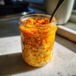 A close-up of delicious Pumpkin Overnight Oats prepared in a mason jar, ready to eat with a spoon.