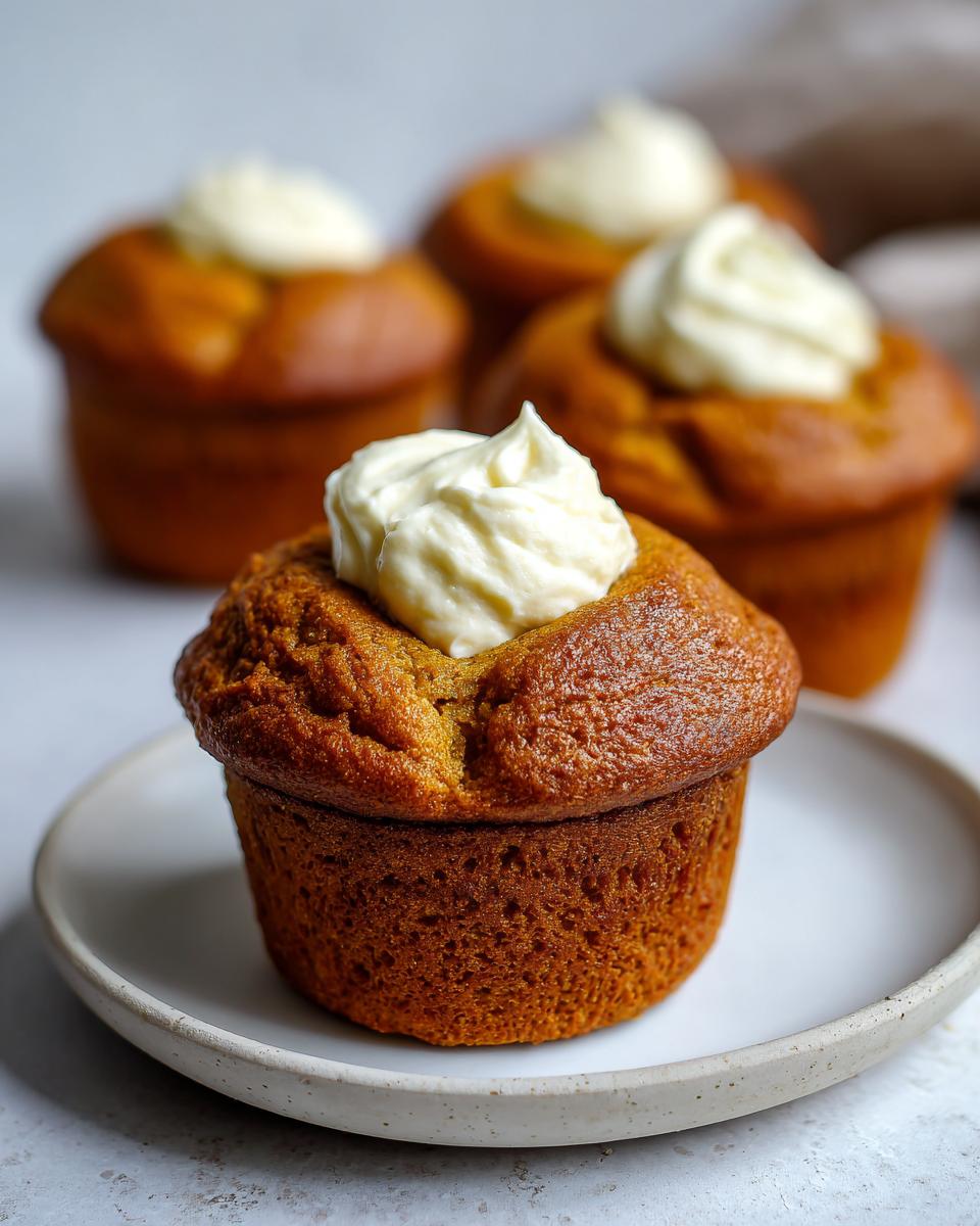 Close-up of a Starbucks pumpkin cream cheese muffin topped with cream cheese frosting.