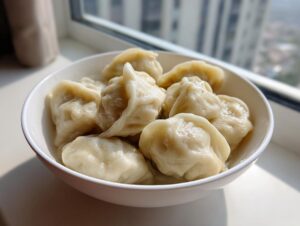 A white bowl filled with freshly cooked Traditional Chinese Dumplings, ready to be served.