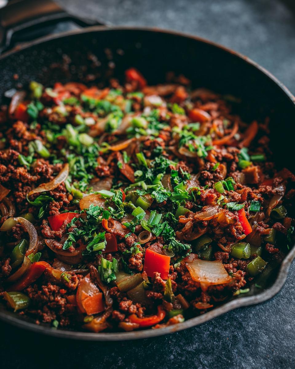 Close-up of a delicious ground turkey skillet with onions, bell peppers, and fresh herbs.