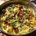 Close-up of creamy Leek Mushroom Gruyere Pasta with sauteed mushrooms and fresh parsley in a skillet.
