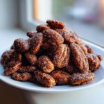 Close-up of a mound of freshly made cinnamon sugar pecans coated heavily in sparkling sugar crystals.