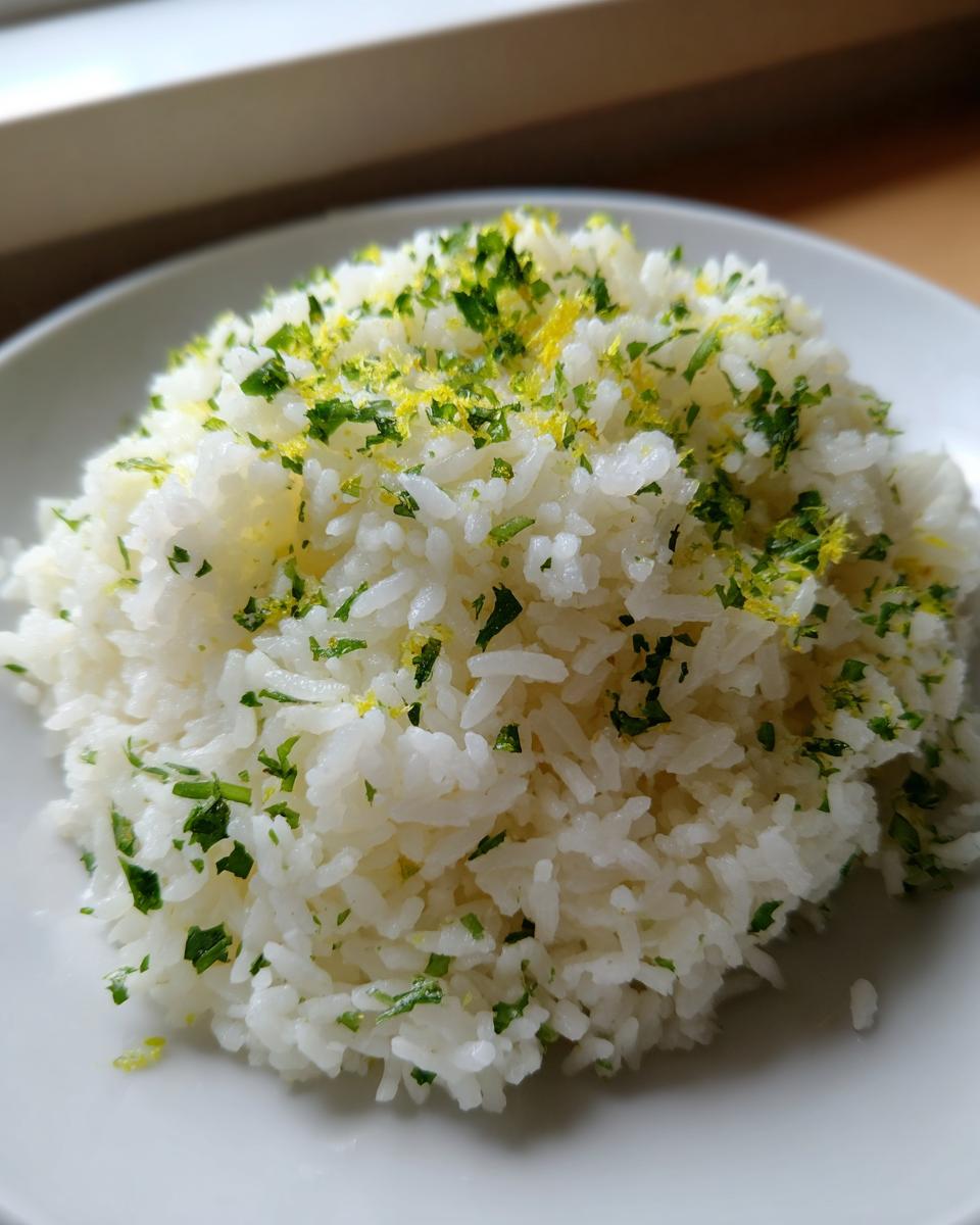 A mound of fluffy white cilantro lime rice topped with chopped cilantro and bright yellow lime zest.