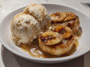 Two servings of quick bananas foster topped with caramelized bananas and vanilla ice cream.