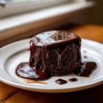 A rich, dark chocolate cake generously topped with a glossy, dripping chocolate sauce recipe.