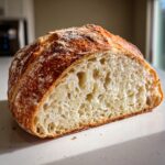 Cross-section view showing the open, airy crumb structure of a homemade loaf of bread.