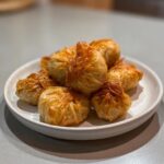 A pile of golden brown, crispy rice paper dumplings served on a small white plate.