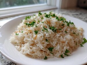 A serving of fluffy white rice pilaf mixed with toasted vermicelli and topped with fresh chopped parsley.