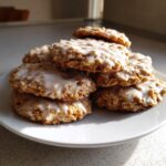 A stack of delicious iced oatmeal cookies topped with a sweet white glaze, ready to eat.