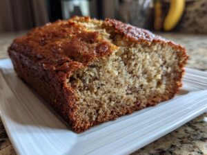 Close-up of a freshly baked loaf of banana bread recipe, showing a moist, golden-brown crumb.