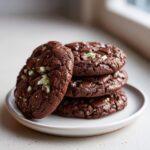 A stack of four rich, dark chocolate Andes Mint Cookies featuring visible green mint chips.