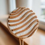 Close-up of a round, white cake decoration with textured brown, wavy stripes, designed as a cinnamon roll cake topper.