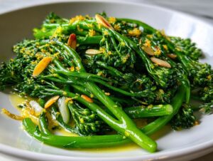 Close-up of a bright green broccolini salad tossed in olive oil, lemon zest, and sliced almonds.